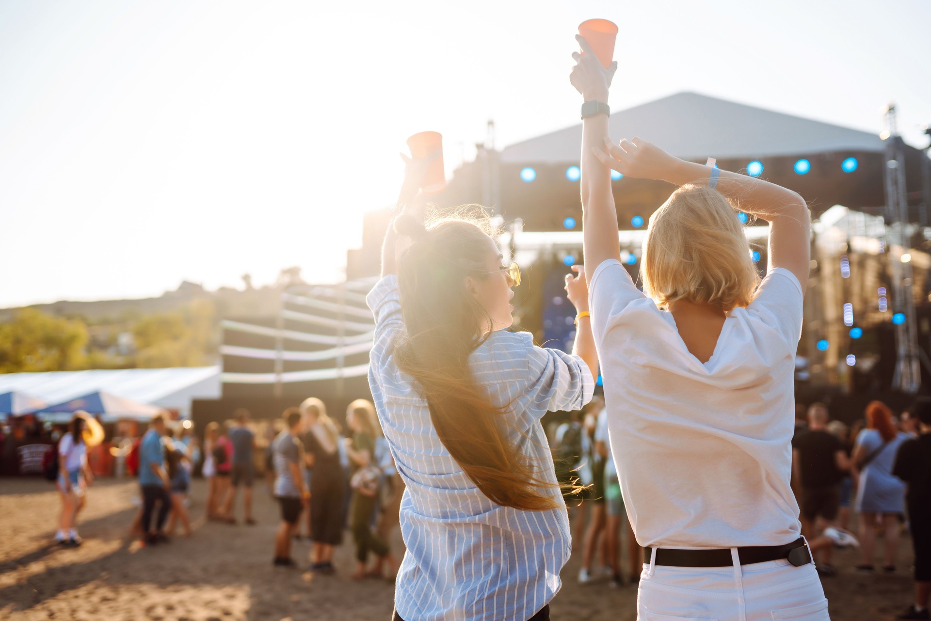 Happy women having fun at a music festival with beer in their hands.
